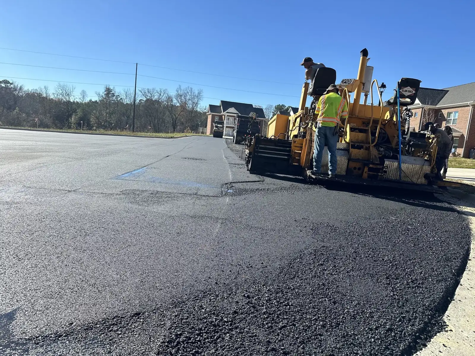 E Wells Paving crew placing fresh asphalt with a paving machine