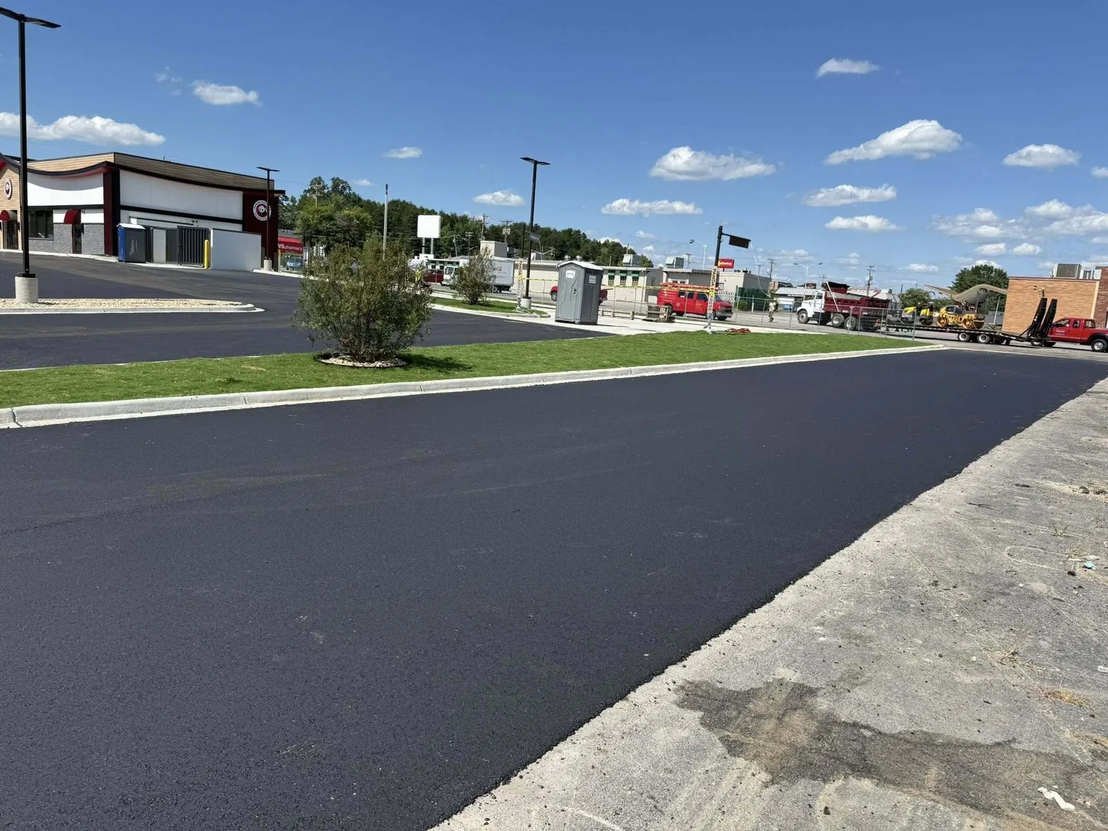 Fresh blacktop across a commercial parking area