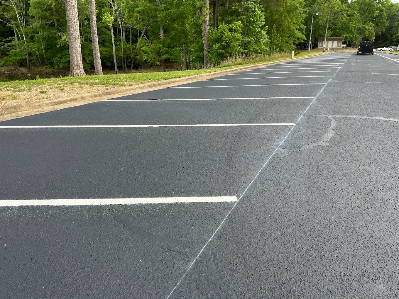 Repaired cracks running beside white parking lot markings